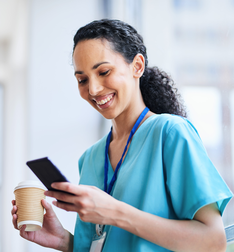 Woman doctor looking at phone and drinking coffee